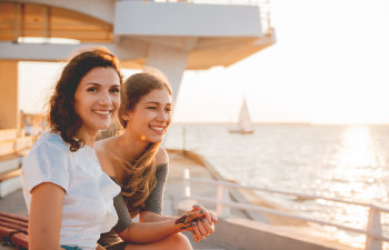 A happy teenage girl and her mother spending time together by the sea.