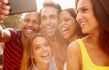 A multicultural group of young people taking selfie.