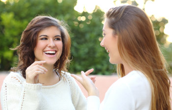 Two cheerful young women with perfect smiles.