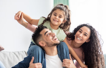 Happy parents playing with their little daughter