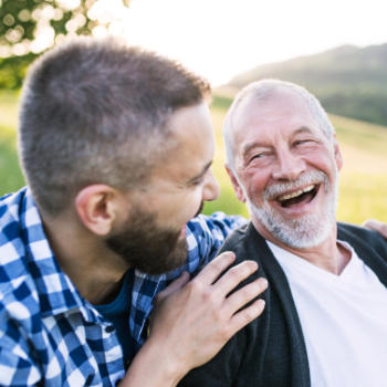 A happy senior man wpending time with his son outdoors.
