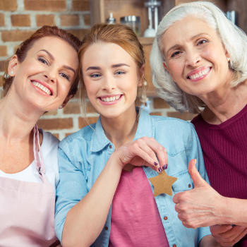 Portrait of broadly smiling teenage girl with her mother and grandmother.