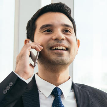 A businessman with a perfect smile talking on the phone.
