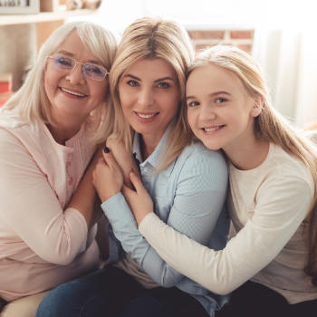 Portrait of broadly smiling teenage girl with her mother and grandmother.
